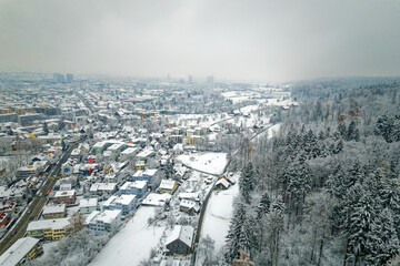 Obraz premium Aerial view over snow covered City of Zürich with skyline and gray cloudy winter sky on a snowy late autumn day. Photo taken December 17th, 2022, Zurich, Switzerland.