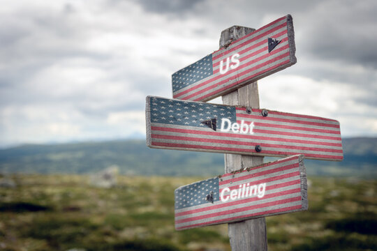 Signpost with the american flag and the text quote us debt ceiling written on it.