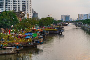 Fototapeta na wymiar Springtime in Saigon, boat on canal, transport spring flower for Tet to Ben Binh Dong open air market, Vietnamese happy with Lunar New Year, Vietnam
