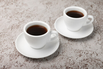 A cup of coffee on a white marble kitchen table. Hot invigorating aroma espresso drink. Place for text. Place to copy. Morning drink.