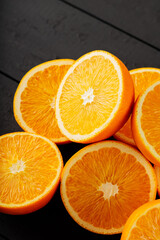 Fresh ripe oranges on a dark wooden table. Fresh citrus fruits for vegetarian dishes