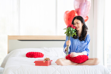 Asian couple Showing love surprise giving flowers or gifts to each other on important occasions such as Valentine's Day birthdays or wedding anniversaries with love and warmth in bedroom of their home