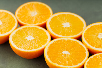 Halves of juicy oranges on a green background. Half cut oranges for making juice. Close up