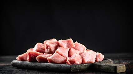A bunch of chopped raw pork on a cutting board. 