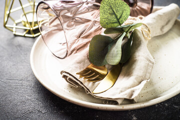 Table setting. White craft plate, cutlery, napkin, wine glass and decor.