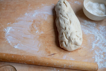 Working on an unfinished rolling pin test. Preparing pastries from dough