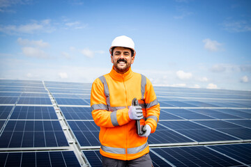 Portrait of solar power plant engineer with laptop computer controlling sustainable energy production.