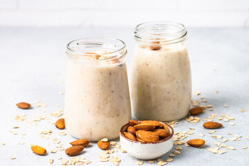 Almond banana smoothie with oat flakes in glass jars.