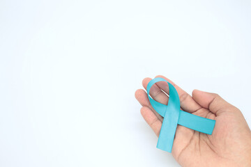hand holding light blue ribbon on white background