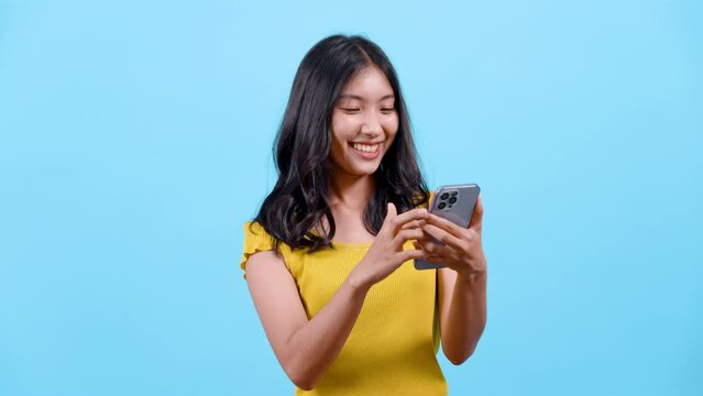 4K, portrait, long haired girl wearing shirt yellow tights, Use your other hand poke phone back forth, Found funny clip made she laugh, happy face, Isolated indoor studio on blue background.