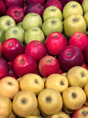 Apple fruits yellow red green in a market.