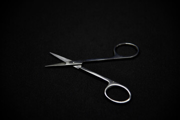 Manicure set on a black background. Scissors and nail tongs. Iron scissors and nail clippers.