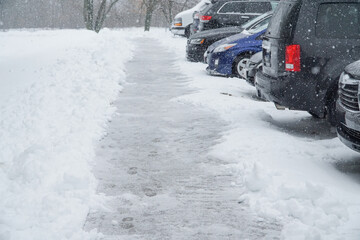Cars parked in row at outdoor parking in winter during snow