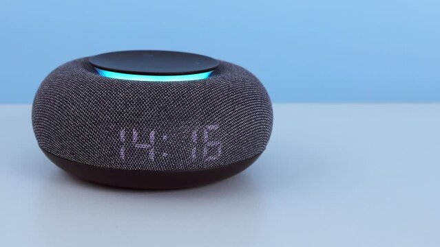 Home mini smart speaker close up. Smart AI speaker concept. Smart home assistant, smart home device on table desk. Voice controlled speaker with activated voice recognition on light background