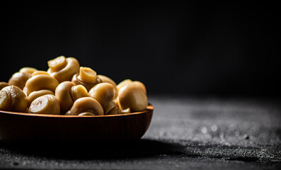 Wooden bowl with pickled mushrooms. 
