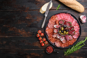Antipasto platter cold meat with chorizo, fuet,salami, salchichon and longaniza on dark wooden background with space for text - obrazy, fototapety, plakaty