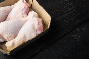 Chicken meat package, in paper Pack, on black wooden table background, with copy space for text