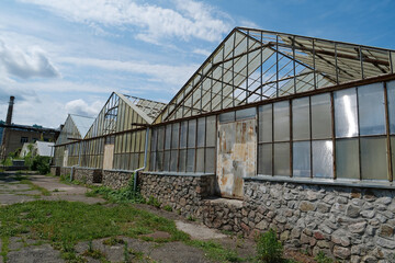 Old abandoned greenhouses with broken glasses