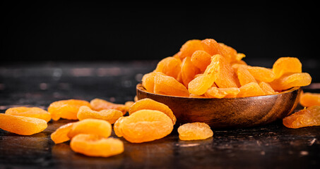 Full wooden plate with dried apricots. 