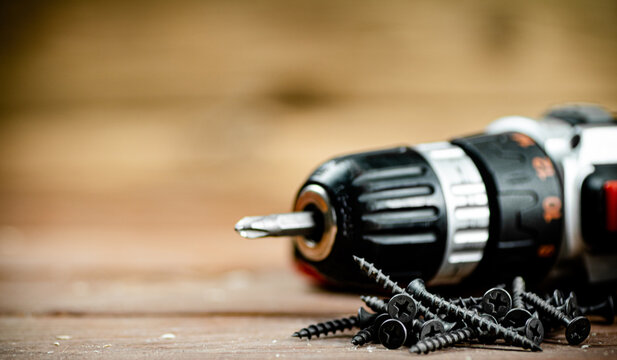 Working tool. Screwdriver with self-tapping screws on the table. 