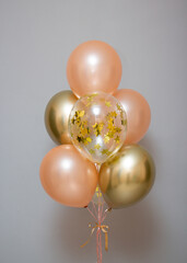 Set of pink and gold balloons on the background of the wall, card with balloons