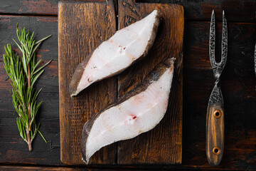 Raw fresh halibut fish steak, with ingredients and rosemary herbs, on old dark  wooden table...