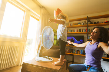 Girl cools off with mom in living room playing