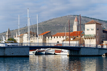 View of the city of Trogir in Croatia. River flowing below the bridge and mountains in the...