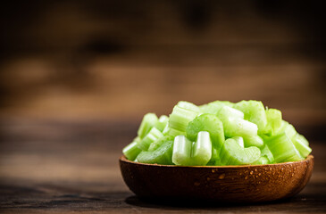 A wooden plate with a piece of celery. 