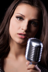 Young woman with microphone in studio