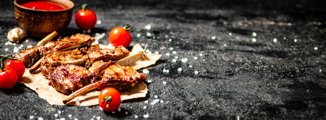 Grilled lamb rack on paper with tomato sauce and cherry tomatoes.  © Artem Shadrin