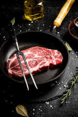 Raw pork steak in a frying pan. 