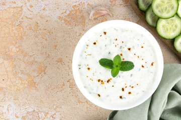 Greek tzatziki sauce or Indian raita with cucumbers, spices and yogurt on a yellow background. Top view, copy space. Greek, Indian cuisine.