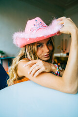Portrait of attractive caucasian woman fashion model with blonde hair in pink cowboys hat , posing 