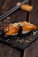 Japanese sushi unagi nigiri sushi smoked eel on wooden background close-up