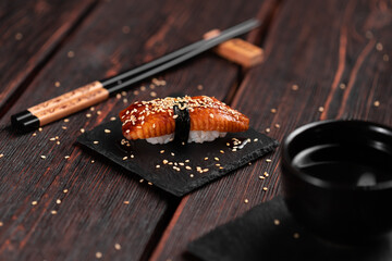 Japanese sushi unagi nigiri sushi smoked eel on wooden background close-up