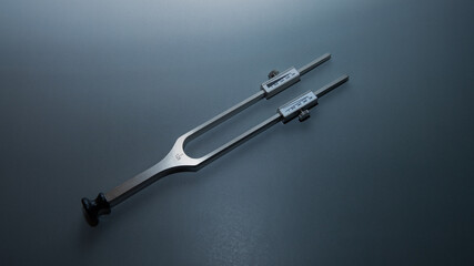 tuning fork C 128 on a grey background with gradation, medical instruments, equipment