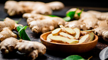 Pieces of fresh ginger on a wooden plate. 