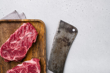 Raw fresh meat Top Blade steaks, on gray concrete table background, top view flat lay, with copy...