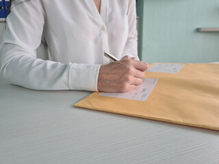 Female clerk at workplace is holding pen in hands and filling out application form template