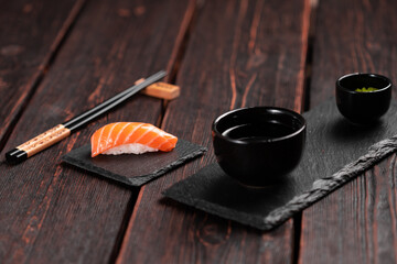 Japanese sushi food. Sushi nigiri with salmon on stone natural background with wooden table