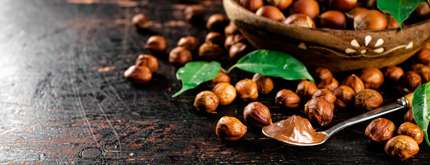 Hazelnut butter in a spoon on a table with leaves. 