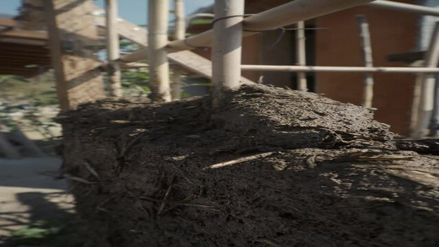 a person mixing straw and earth for the technical construction of bioconstruction