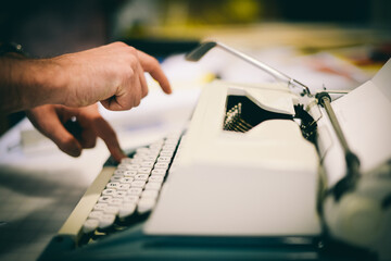Typing a document using fingertips on an analog typewriter