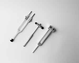 tuning fork C 128 on a white background with gradation and neurological hammer