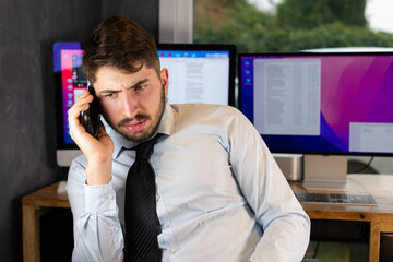 jeune homme d'affaires ou employé qui téléphone. Il est en colère et se dispute avec quelqu'un....