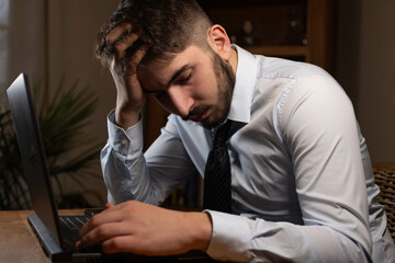 jeune employé de bureau ou homme d'affaire fatigué et stressé travaille tard au bureau avec son...