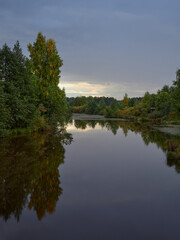 Nature of Northern Europe: forest river, nature reserve, autumn, sunset.