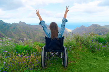Disabled handicapped woman in wheelchair on mountain hill enjoying view