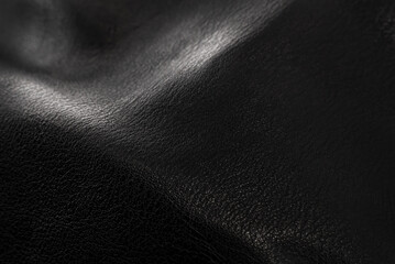 Black leather texture. Abstract background of dark leather with small roughness and scuffs